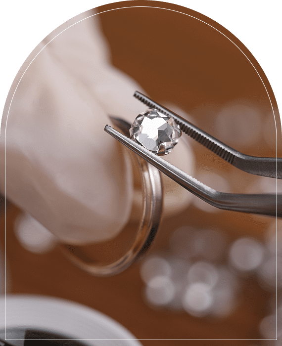 Diamond held by tweezers, close-up view.