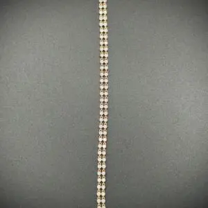 Close-up of a chain with rectangular links on a dark surface.