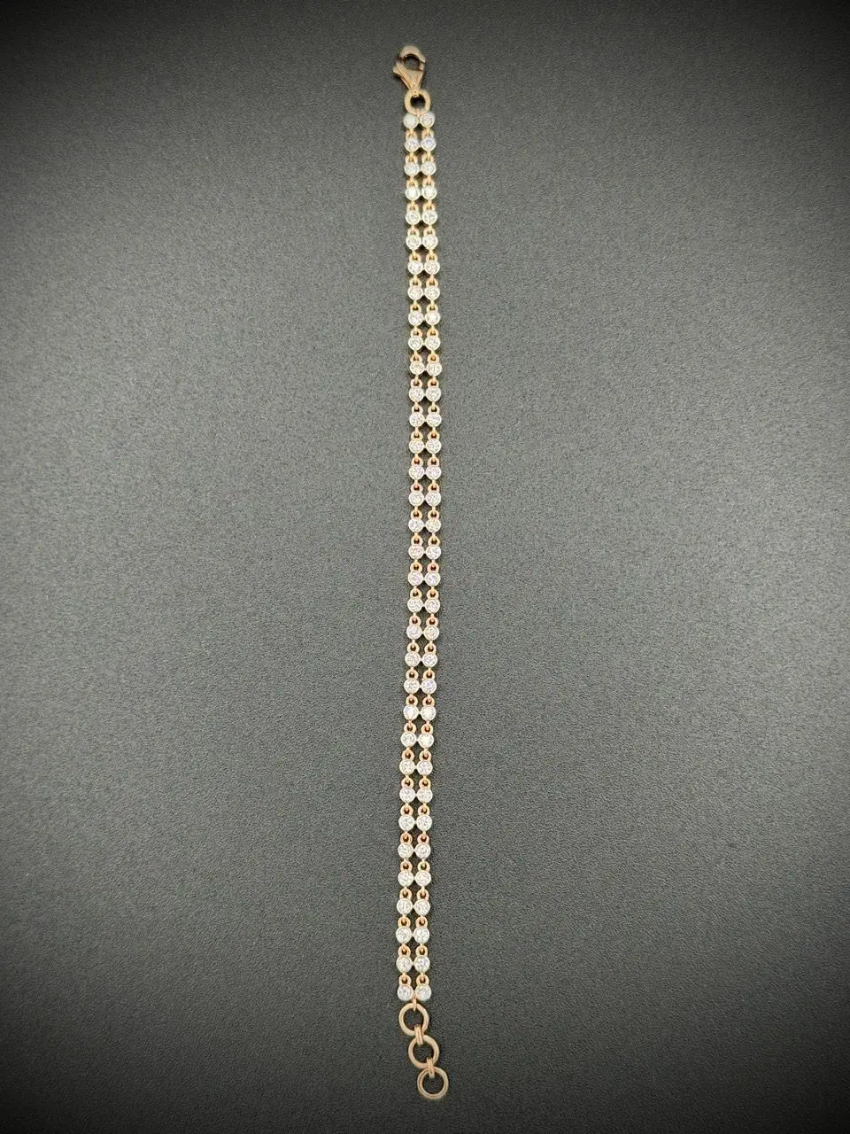 Close-up of a chain with rectangular links on a dark surface.