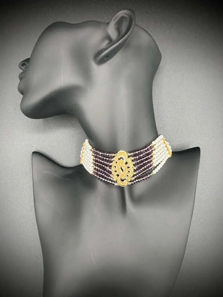Elegant gold and white choker necklace on a mannequin.