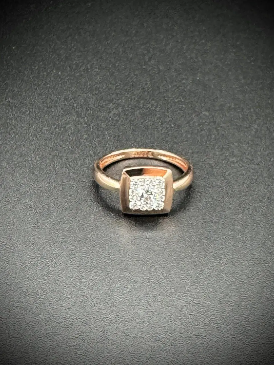 Elegant gold ring with a square diamond centerpiece.