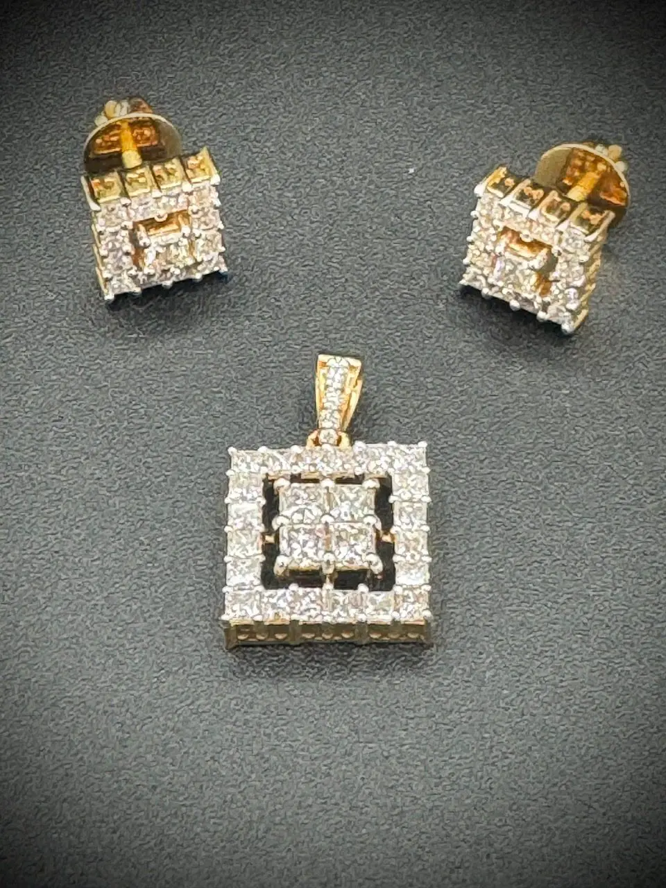 Diamond-studded square pendant and matching earrings with gold accents.
