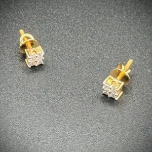 Elegant gold and diamond stud earrings on a dark surface.
