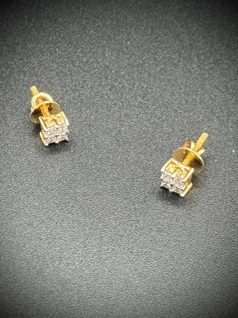 Elegant gold and diamond stud earrings on a dark surface.