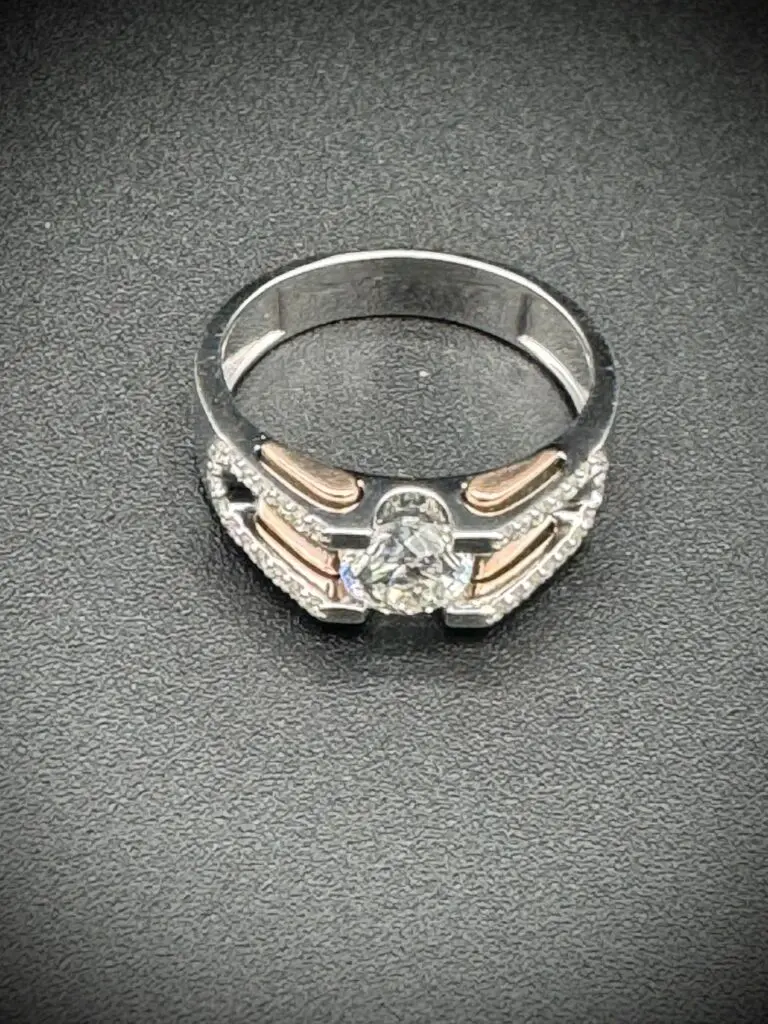 Elegant silver ring with intricate design and central gemstone.