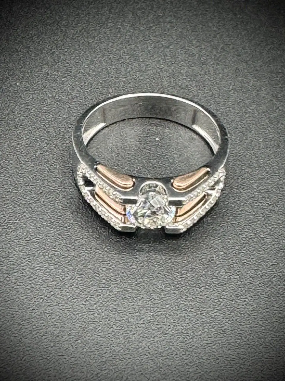 Elegant silver ring with intricate design and central gemstone.