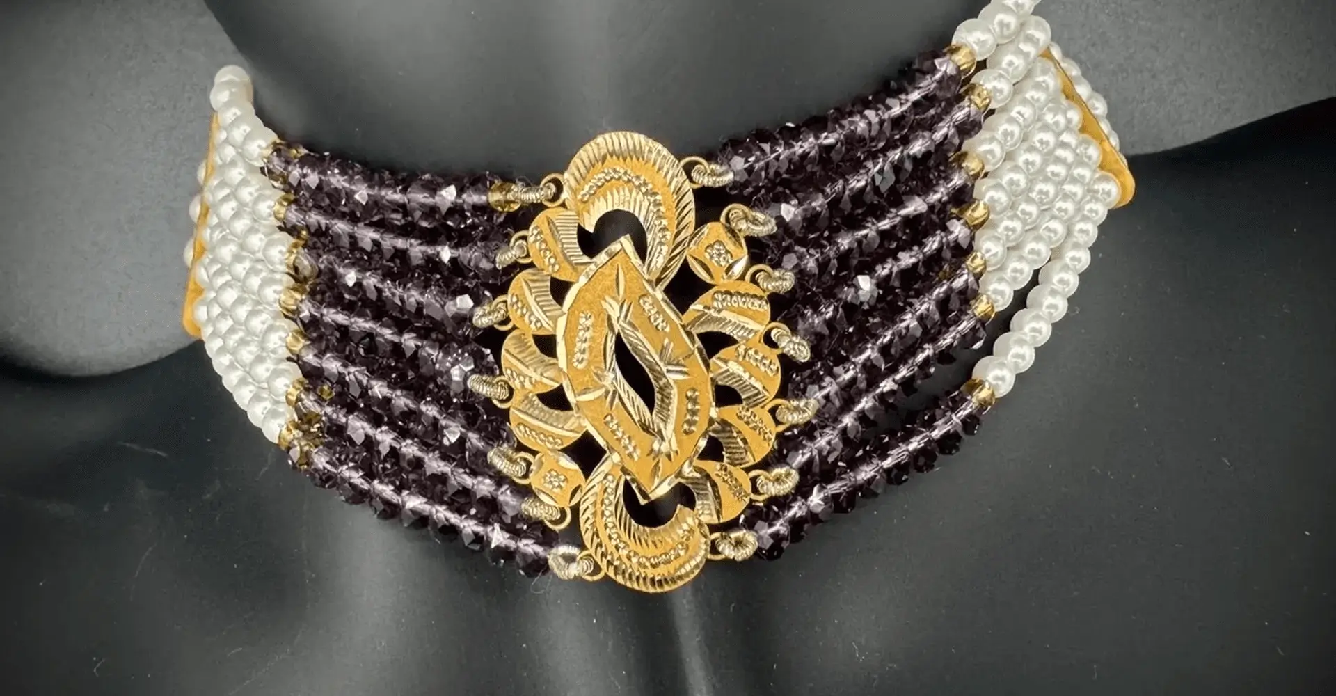Intricately designed gold and black traditional necklace with detailed craftsmanship.